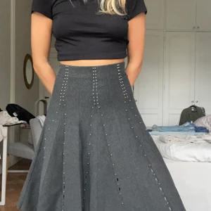 Kjol Sandro - En yllekjol från sandro som är högmidjad. Små metall nitar som detaljer. Går även att vika ned om man inte vill ha så högmidjat! Passar medium-small storlek! 