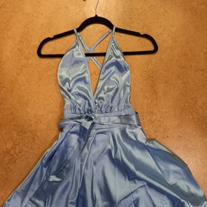 Festlig klänning  - En festlig klänning i en fin blå färg. Har ett band man kan knyta i midjan. Djup v-ringning. Skriv vid intresse eller om du vill ha fler bilder. Köpare står för frakt. Besök gärna min profil då jag har mycket som jag säljer just nu!