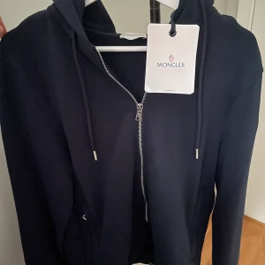 Moncler zip Hoodie  - Moncler zip hoodie, aldrig använd tagsen sitter kvar på tröjan. Nypris 5 500.
