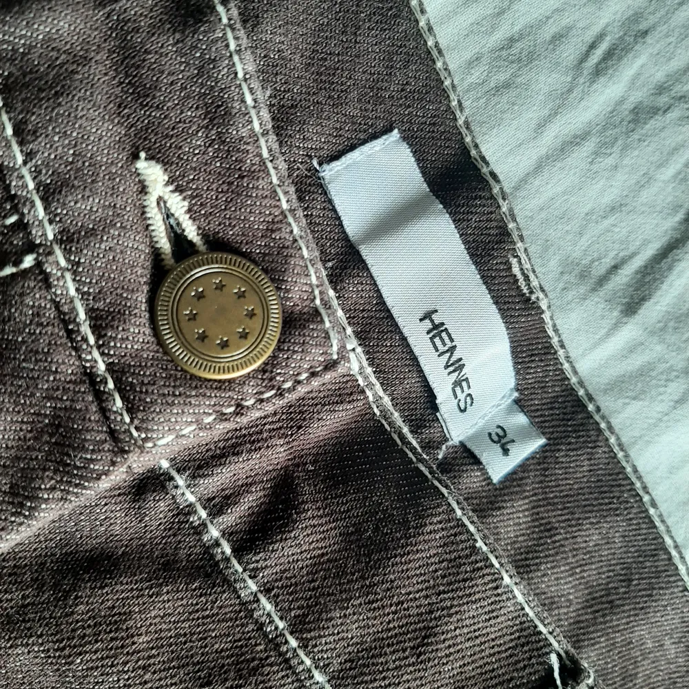 Ett par bruna jeans i storlek 34 (dam). Byxorna är vintage H&M och har synliga sömmar i en ljus beige färg. Byxorna är gjorda i ett tunnare jeans tyg och är i bra skick. (70% Bomull 27% Polyester 3% Elastan). Jeans & Byxor.