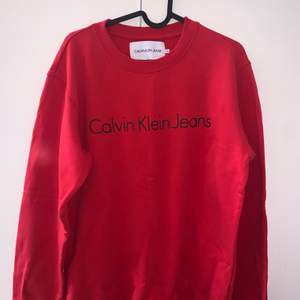 Röd sweatshirt från Calvin Klein, knappt använd, storlek medium.