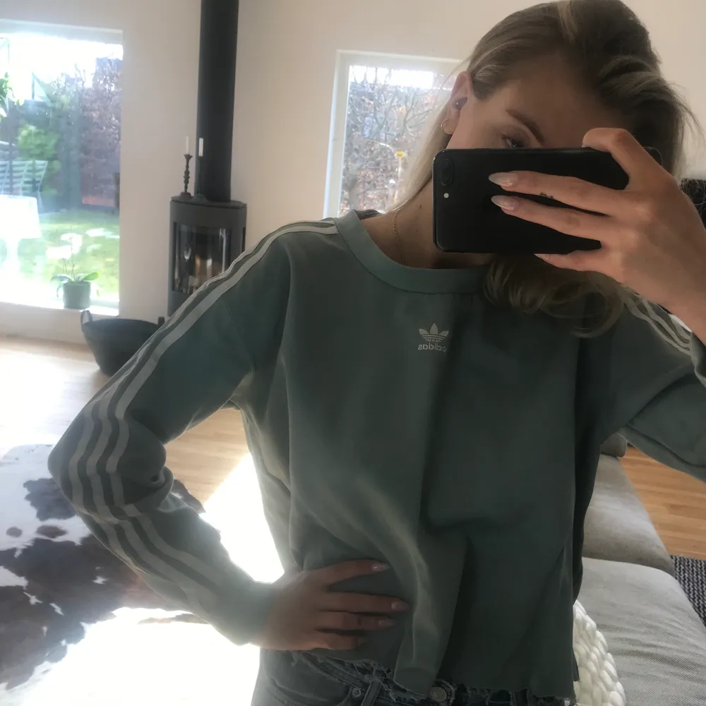 Skitcool adidas sweatshirt i en snygg blå/turkos färg. Storlek S men snyggt oversized. Har själv klippt av den själv då jag tyckte den var för lång innan. Färgen är som i första bilden. På andra bilden visar den sig lite mörkare..! Köptes för 599kr . Tröjor & Koftor.