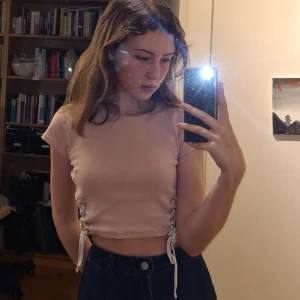 Rosa t-shirt - Rosa T-shirt med vita band på sidorna (löstagbara) i storleken är xs/s eftersom att tyget är relativt töjbart. PRIS:60 Sek +frakt