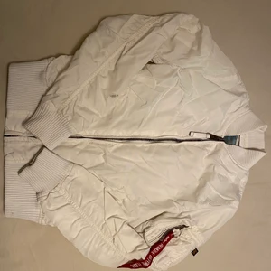 Alpha industries inc.  - vit bomberjacka från Alpha Industries. Passar inte längre och därför säljs. Har en liten fläck på nedre delen av högra armen och är om sydd under armhålan då den öppnades upp lite, dock inget som syns. Passar fint till sommaren och går bra att ha kofta under 