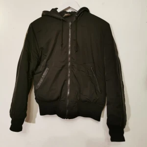 New Black jacka S - NEW BLACK, Svart bomber jacka med läderdetaljer på huva, fickor och armar. Storlek S. Bra skick.
