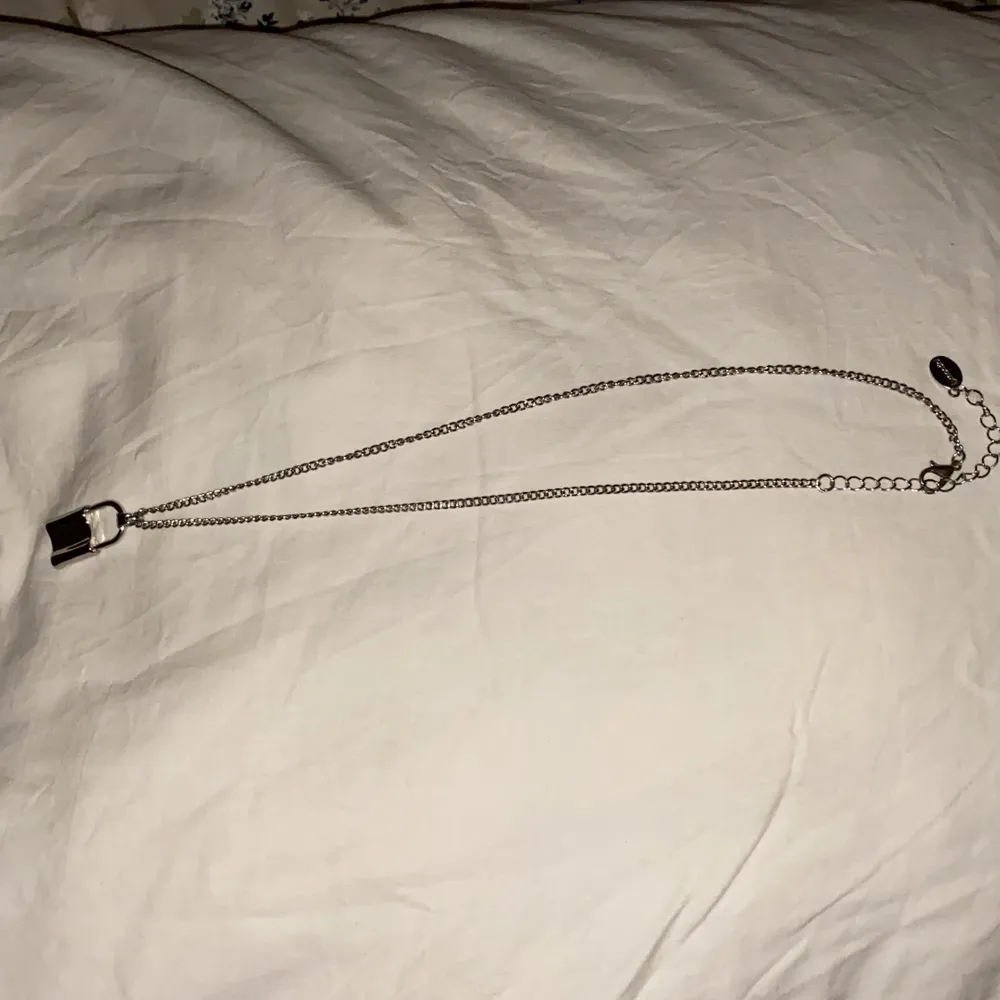 Halsband med ”lås” hänge, ca 52cm på längsta snäppet. Aldrig använt. . Accessoarer.