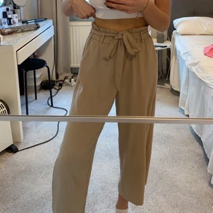 Beiga byxor  - Säljer dessa byxor i en jättehärlig beige färg, perfekta speciellt på sommaren då de är ganska tunna och lite kortare i modellen. De har stretchig resår i midjan och ett knytband som man även kan ta bort om man vill!🤎säljer då de inte kommer till användning