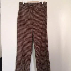 Dressy wide leg trousers Monki - Hundtandsmönstrade (beige och mörkbrun/nästan svart) från Monki. Modellen heter "Dressy wide leg trousers" och finns på Monkis hemsida, dock säljs inte denna färg längre. Sista bilden är samma byxa men i annan färg. Fint skick, använda typ 2 ggr. Storleksmärkta 38, men passar mig som oftast  har 36. Pris kan ev diskuteras.