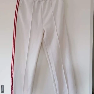 Vita festbyxor med rand - Något slitna men syns inte för mycket, jättesnygga!! Storlek 40 passar mig som har 42/44 också!