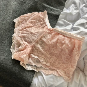 Spetsshorts från Gina Tricot - Supergulliga spetsshorts från Gina Tricot lingerie! Satinband i midjan och en liten rosett fram. Använda men i fint skick! Storlek XS. Frakt på 22kr tillkommer!