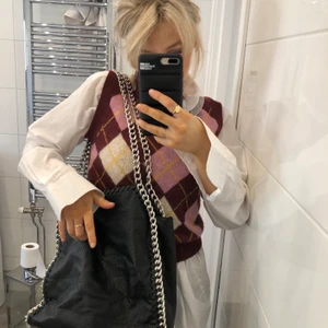 Svart kedjeväska - Säljer denna gamla väskan från TIAMO som jag haft till skolan! Väskan är mycket använd så den är sliten vid dragkedjan och innertyget, kan säkert sys om ifall man är duktig på det. Väskan är i fakeläder och köptes för cirkus 500 lappen. Fråga gärna om fler bilder så kan jag visa mera! Köparen står för frakten (62kr)och betalning sker via Swish! Titta gärna på mina andra annonser🤎🥺