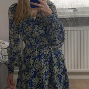 Blommig klänning - Säljer denna fina sommarklänningen! Jättefin modell med volang i ärmarna. Den är tyvärr lite för liten för mig, är 164 cm lång. Använd 3 gånger ungefär 💞💞 Köparen står för frakten! 