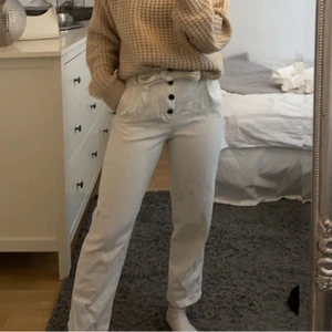 vita jeans  - Vita jeans med knappar och knytning. Inte alls genomskinliga och i bra skick, dessa är köpta från H&M. Köparen står för frakten! 
