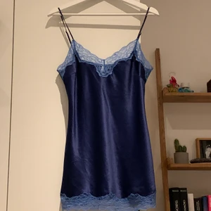 Blått linne - Snyggt blått linne med spetsdetaljer från märket darjeeling i 100% satin.