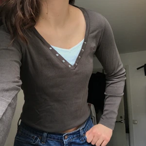 Longsleeve top - Så fin långärmad i en grön/grå/brun färg med en vit detalj som sticker fram. Så skönt och stretchigt material