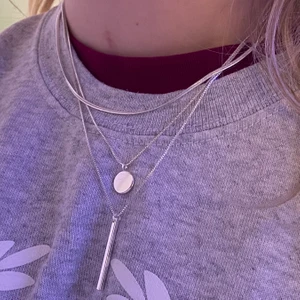 Tre i ett halsband - Ett tre i ett silverhalsband med tre olika kedjor i en. Ena kedjan har en liten platt cirkel och en annan kedja har en liten längre fyrkantig stav. Kedjan är justerbar. Aldrig använd. Säljer pga att den inte kommer till användning. Kommer från hm💕 exkl frakt