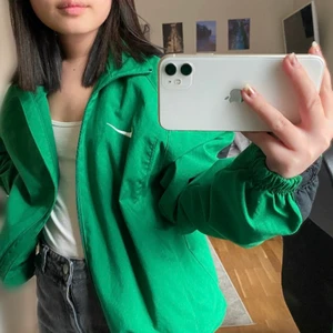 Nike vindjacka grön storlek S - Grön Nike jacka i tunnare material. Fler bilder kan fås privat. Inköpt second hand men säljer/kollar intresse då den är lite stor för mig. Den är storlek S och på lappen står det 173 cm. Jag är 157 cm lång så på mig är den lite stor men den borde passa S-M beroende på hur man vill att den ska sitta. 😊 pris kan diskuteras