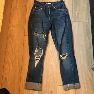 Jeans - Blå jeans från Gina tricot i storlek 34, de har hål på tre ställen som man ser på bilderna. Fickorna på framsidan är ej ihopsydda.