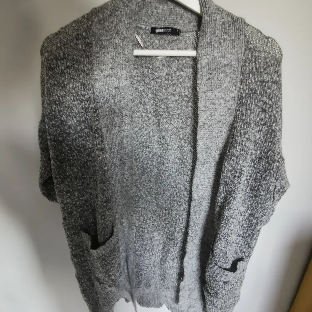 Grey knitted cardigan, it has short sleeves and large pockets. . Tröjor & Koftor.