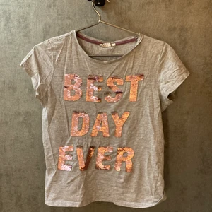 Kappahl t-shirt strl 170/XS - Fin t-shirt med silver/rosa paljetter som man kan ändra färg på med hjälp av handen. Säljer plagget eftersom det blivit för litet