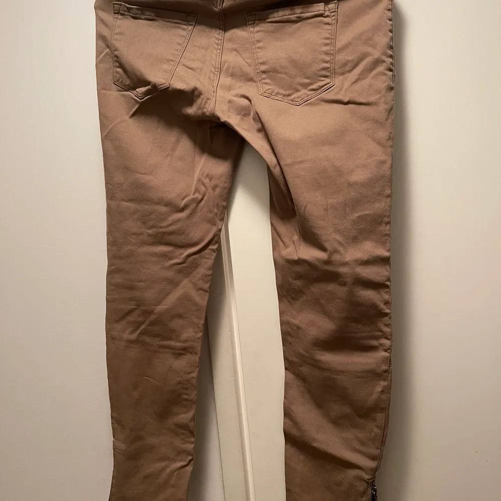 Khaki jeans med fina detaljer/ dragkedja på ankeln. Jeans & Byxor.