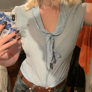 Blå topp - Söt blå skjorttopp med krage och knytning. Lite gammaldags stil och så söt på sommaren! Sparsamt använd och köpt seconhand!💙