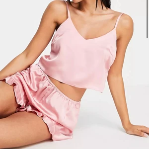 Satin pyjamas set - Dusty rose / rosa / beige-rosa satin pyjamas set från missguided! Fräsch och sparsamt använd.🌟 Setet består av ett linne som är croppat/ magtröja och ett par shorts med volang. Inköpt på deras hemsida för ett år sedan. Hämtas i Gamla stan/ Frakt tillkommer. Skriv vid frågor/mer bilder!