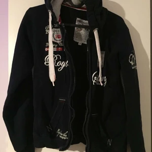 Mörk blå zipup med märken - Riktigt snygg mörkblå zipup. Märken på båda sidorna vid bröstkorgen, men tyvärr inga jag känner igen. Fick den i present så vet tyvärr inte var den är ifrån! Kontakta vid intresse. (Direkt köp 250, högsta bud på 180 just nu!)