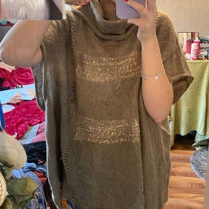 Brun stickad poncho - Säljer denna bruna stickade poncho med glitter detaljer på. Har en liten mysig krage och är i one size samt köpt från Kappahl 🤎🤎