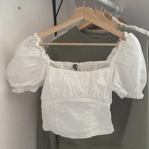 Topp - Säljer min finaste topp från HM då den nu blivit för liten.  Puffiga ärmar och stretch i ryggen. Superfint skick!! Storlek 34, alltså XS.