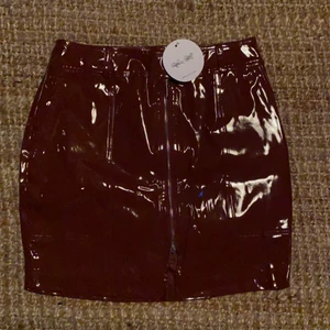 Vinröd lackkjol oanvänd  - Oanvänd lackkjol från NAKD/Rebecca Stella. Storlek M