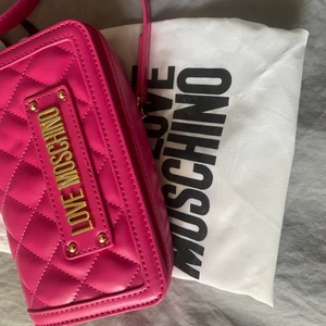 Moschino väska - Snygg rosa moschino väska som aldrig använts. Väskan har inte några som helst defekter då den knappt ens tagits ur dustbagen som tillkommer. Pris går att diskutera💕 köpt för ca 1200kr