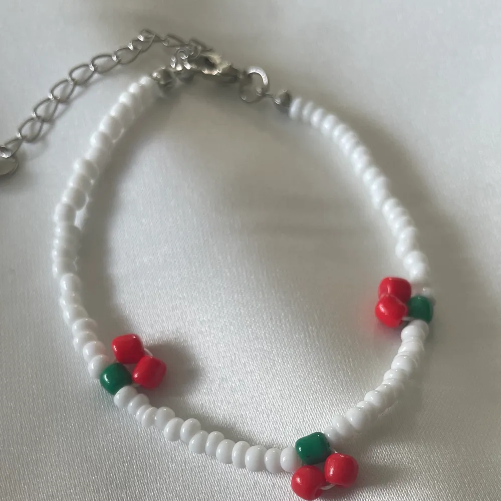 Pärl armband med justerbart längd i bak och färg röd vit grön . Accessoarer.