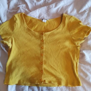 Topp - Gul ribbad top från monki☀️🌸croppad model med funktionella knappar i fram, super gullig till kjol eller jeans☺️en gammal favorit som inte längre används, välanvänd men i fint skick. Storlek M (färgen gör sig bäst på första bilden) 