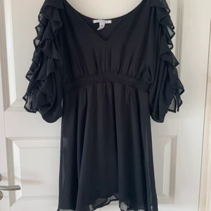 Klänning - Svart klänning från nelly med volanger och öppna axlar. Strl M, säljer för 80kr. Frakt tillkommer! 