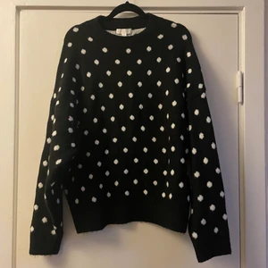 Svart prickig stickad tröja - Jättefin svart stickad tröja med vita prickar. I princip aldrig använd. Storlek M. Frakt tillkommer 