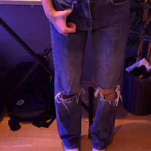 Gina byxor med hål - Säljer dessa blåa jeans från Ginatricot då dom knappt passar mig längre. Super bra skick och inga hål förutom dom på knäna som ska vara där. 