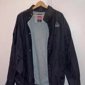 Regnjacka - Svart kappa regn/vindjacka i storlek L, köpt secondhand men aldrig kommit till användning 