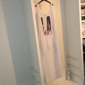 Klänning  - En vit klänning i en M skulle jag uppskatta, med LA tryck, aldrig ansvällt, 