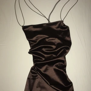 Satin klänning från H&M  - Helt oanvänd klänning från hm i brun färg. Mer brun i verkligheten än på bilderna. Jättefin men har inte kommit till användning bara🤎Den är även korsad i ryggen, väldigt fin detalj!