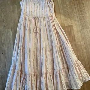 Säljer denna fina rosa klänningen med guldiga detaljer som är köpt i England för ett tag sedan, perfekt såhär när sommaren börjar närma sig! Vet tyvärr ingen storlek då lappen är bortklippt. Skulle uppskatta den som xxs-xs beroende på hur man vill ha den (skulle eventuellt kunna passa en xxxs)  Fler bilder kan skickas, skriv om ni har några frågor💕  110kr + frakt (köpt för 250)