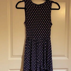 Jumpsuit/ playsuit mörkblå - Mörkblå playsuit/ jumpsuit med vitt mönster. Hål i ryggen. Fins en knapp längst upp bak i ryggen som du kan öppna för att lättare få på den.