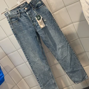Jeans från ONLY - Oanvända jeans från ONLY, höga i midjan och rak modell. 27/32 i storlek 