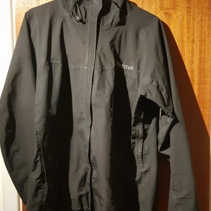 Marmot vind/regnjacka  - Svart jacka i gortex. Dragkedjor i sidorna för vädring.