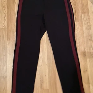 Kostymbyxor  - Säljer ett par superfina kostymbyxor med vinröda ”sträck” på sidan av byxan, är ifrån kappAhl i storlek M. Aldrig använda.