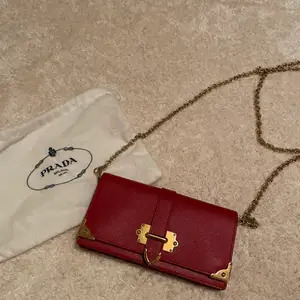Prada red shoulder bag with gold chain details 