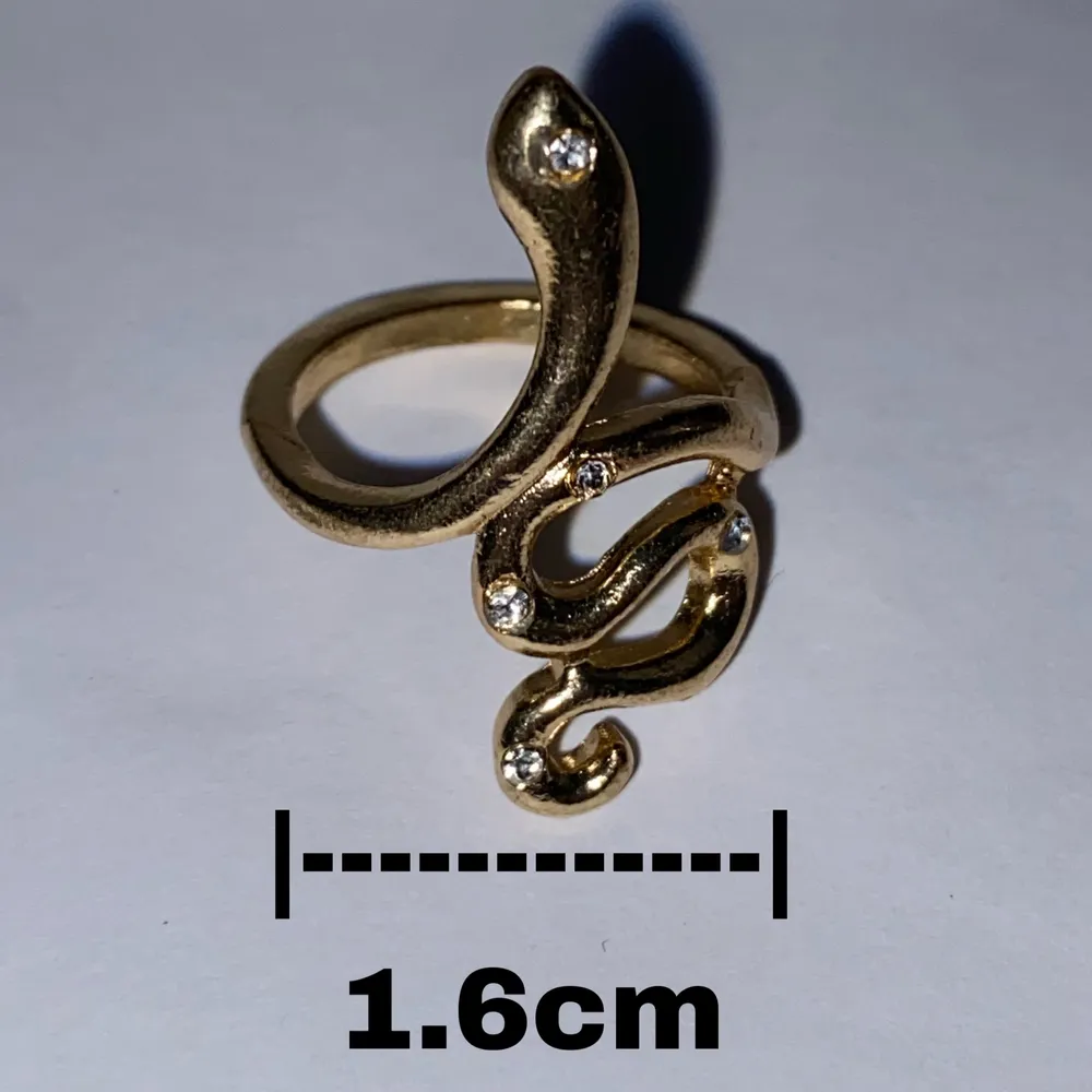 Silverring i form av en orm med kristaller och gulddetaljer.. Accessoarer.