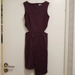 Lila klänning med slits  - Lila klänning med slits från 5 inch and up for Nelly, storlek XS. Klänningen är omlott vid benen och har öppning vid sidorna under bysten. Sparsamt använd. 