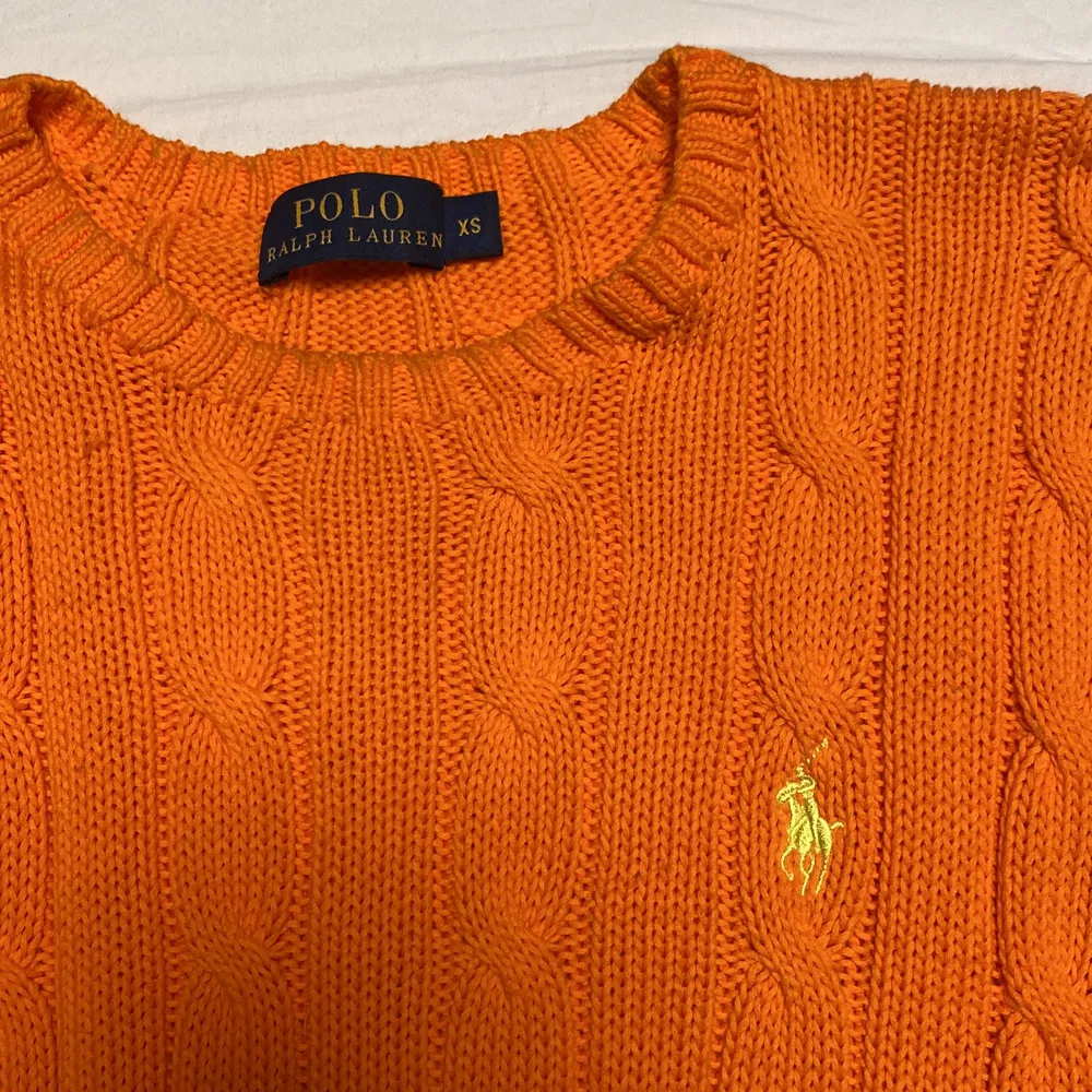 En stickad tröja från Ralph Lauren i storlek XS. Stretchig i materialet och härlig orange färg med ett gult märke. (Kan eventuellt också frakta men köparen står för frakten) 🧡. Stickat.