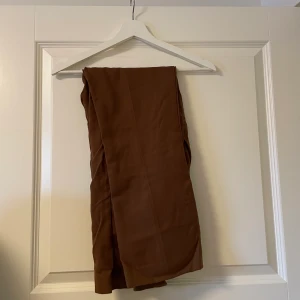 Kostymbyxor ribbade från Gina Tricot  - Ribbade kostymbyxor från Gina, bruna i storlek 36. Väldigt fint skick. 